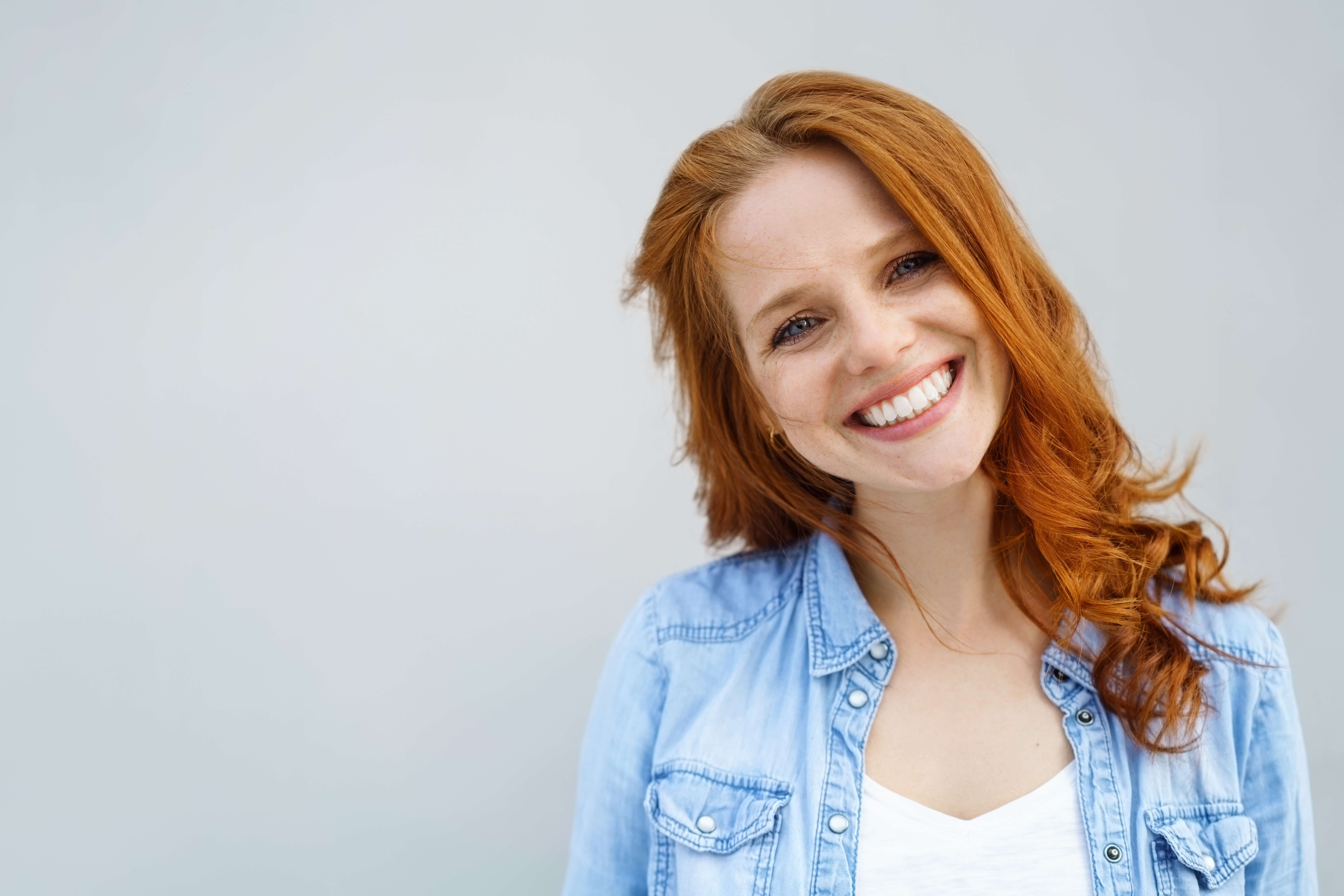 disallineamento dentale: ragazza sorridente con capelli rossi