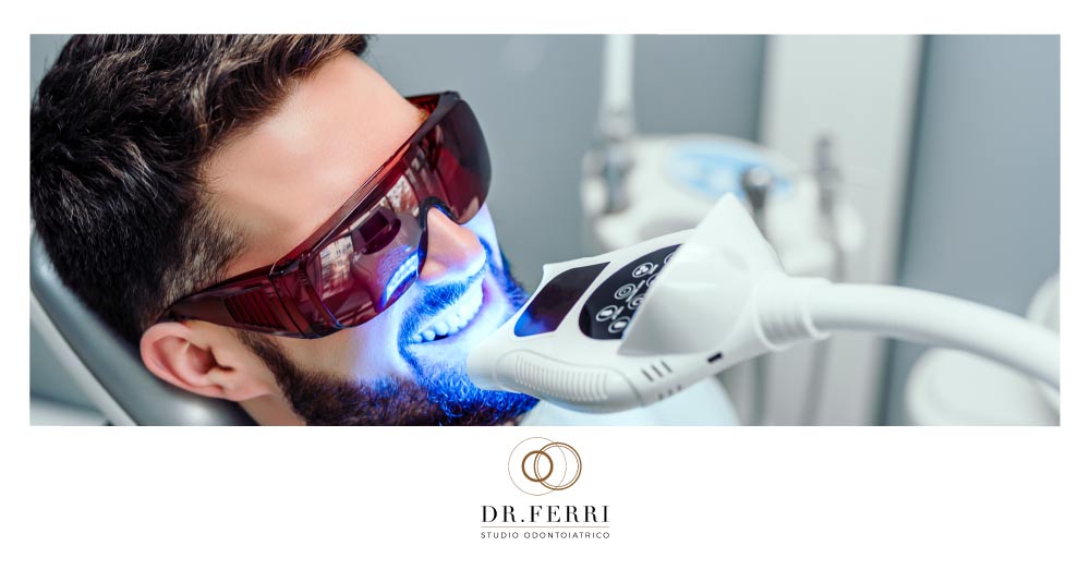 sbiancamento dentale fa male: immagine di paziente con occhiale per laser che si sottopone a trattamento